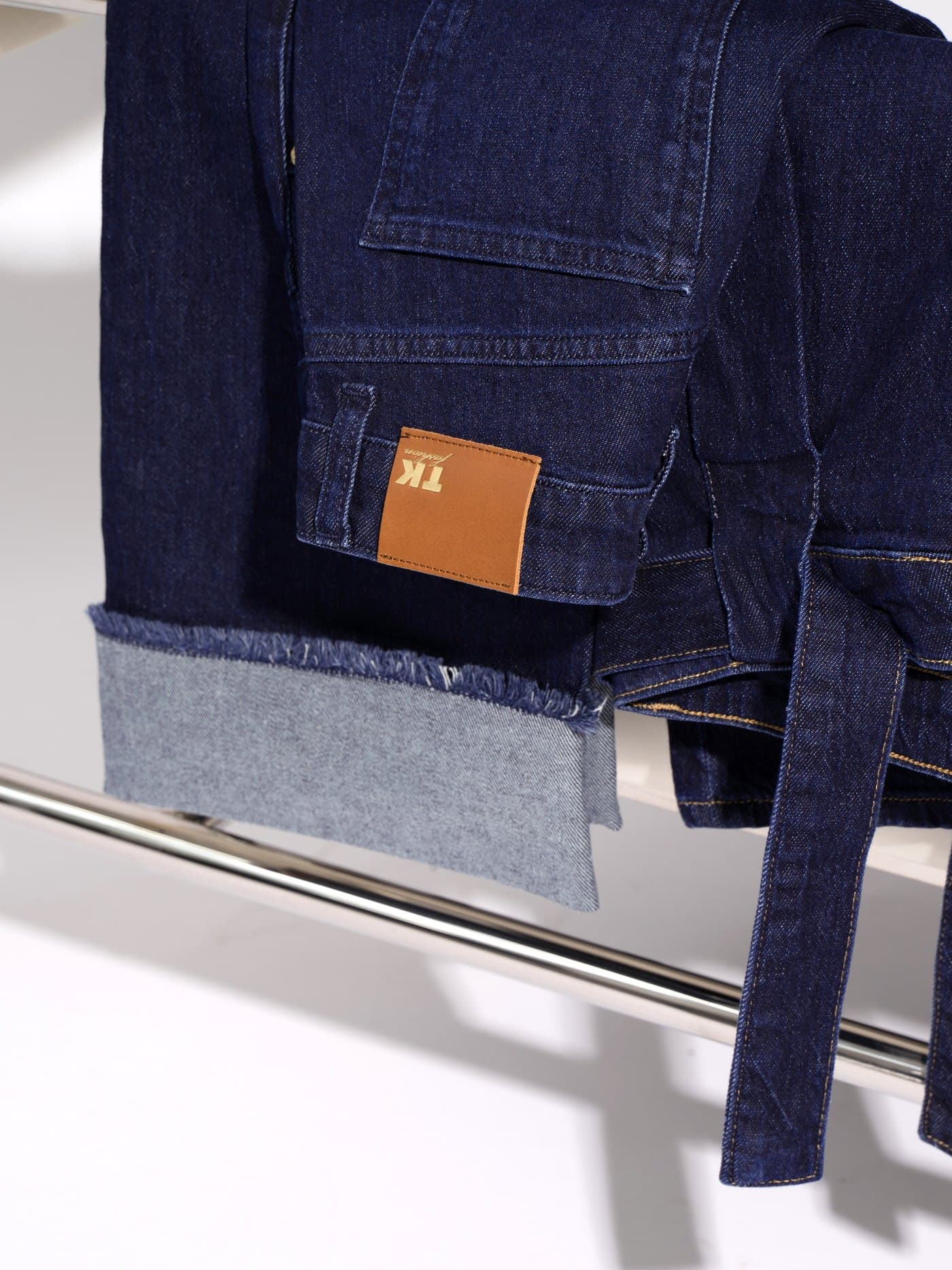 TK Fashion — folded-cuff jeans with leather brand patch